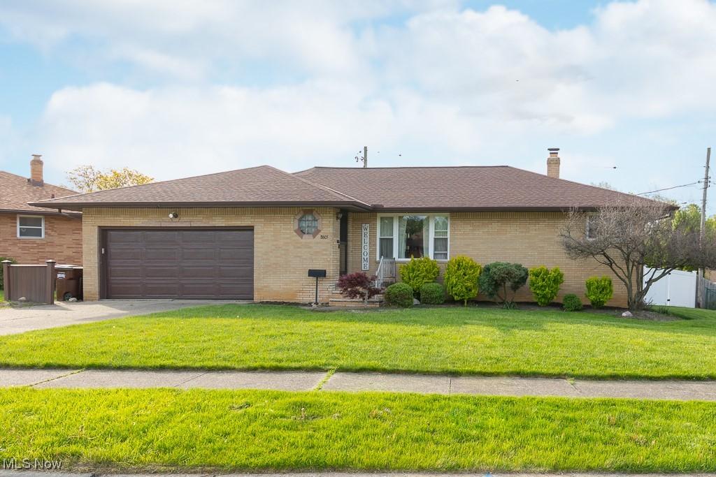 8605 Banner Ln, Parma, OH 44129 - ranch-style home with a garage, brick siding, driveway, and roof with shingles