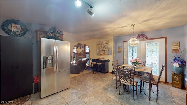 dining space with a chandelier, arched walkways, and light tile patterned flooring