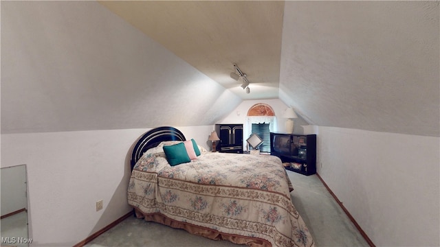 carpeted bedroom with lofted ceiling, track lighting, baseboards, and a ceiling fan