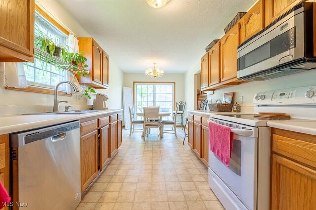 1402 SW Channonbrook St SW, Canton, OH 44710 - kitchen with stainless steel appliances, a chandelier, light countertops, brown cabinets, and light floors