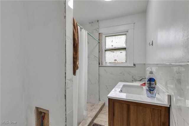 1348 Himrod Ave, Youngstown, OH 44506 - bathroom featuring a marble finish shower, vanity, tile walls, and marble look tile flooring