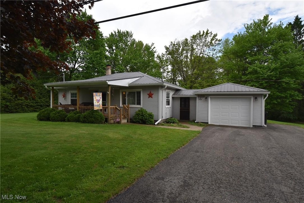48481 Metz Rd, New Waterford, OH 44445 - view of front facade with a porch, a garage, asphalt driveway, and a front yard