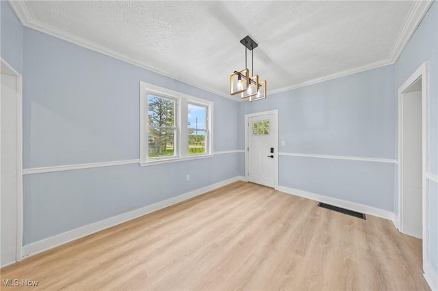 9324 Columbia Rd, Olmsted Falls, OH 44138 - unfurnished dining area with a chandelier, a textured ceiling, light wood finished floors, ornamental molding, and baseboards