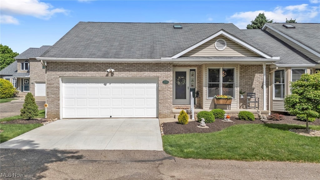 2532 Marsh Ave NW, Canton, OH 44708 - view of front facade with brick siding, a garage, driveway, a porch, and a front yard