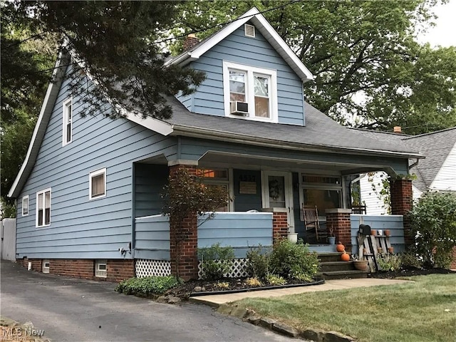bungalow-style house featuring covered porch and a chimney