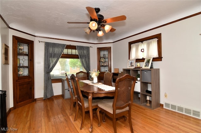dining area featuring hardwood / wood-style flooring, baseboards, ornamental molding, and a ceiling fan
