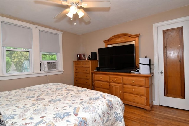 bedroom featuring light wood-style flooring, ceiling fan, and cooling unit