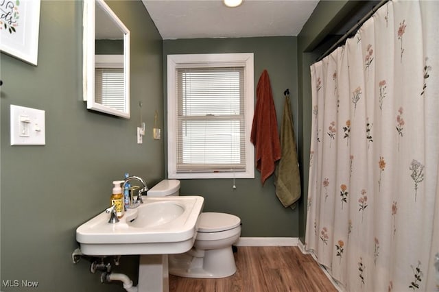 full bath with wood finished floors, toilet, baseboards, and a shower with shower curtain