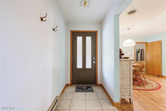 entryway with baseboards and light tile patterned floors