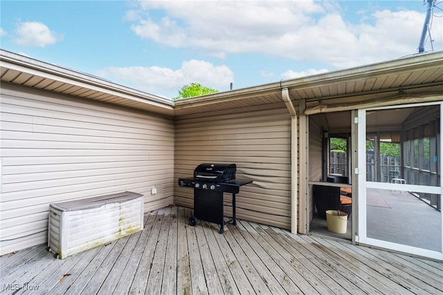 wooden deck with area for grilling and a sunroom