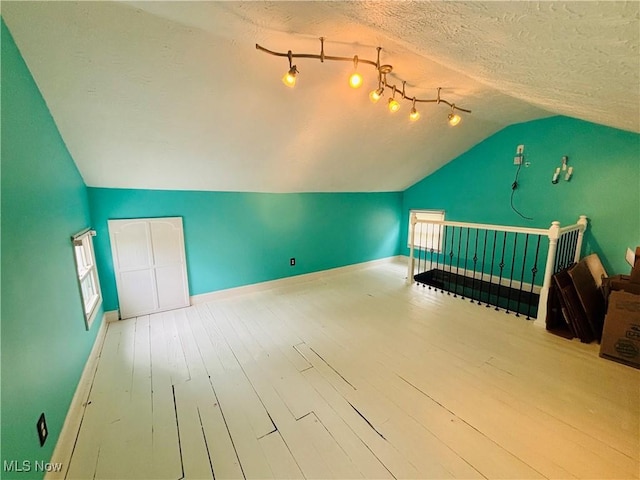 211 Kenwood St, Marietta, OH 45750 - additional living space featuring lofted ceiling, wood finished floors, a textured ceiling, and baseboards