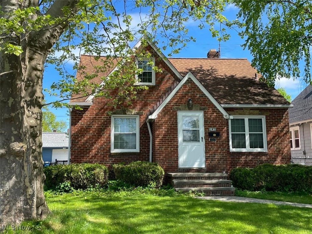 13432 Wainstead Ave, Cleveland, OH 44111 - tudor house featuring brick siding, a front yard, and a chimney
