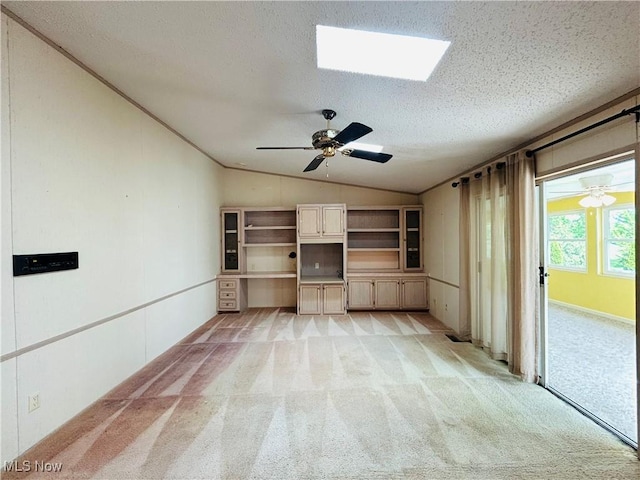 2270 S Commodore Ct, Lakeside-Marblehead, OH 43440 - unfurnished living room with vaulted ceiling, light colored carpet, a textured ceiling, a ceiling fan, and a skylight