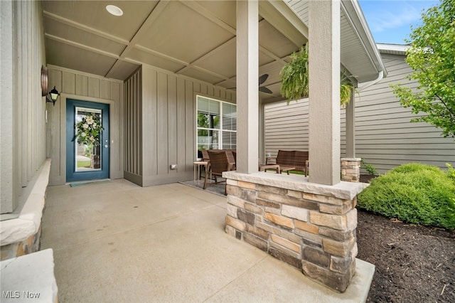 entrance to property with board and batten siding and a ceiling fan