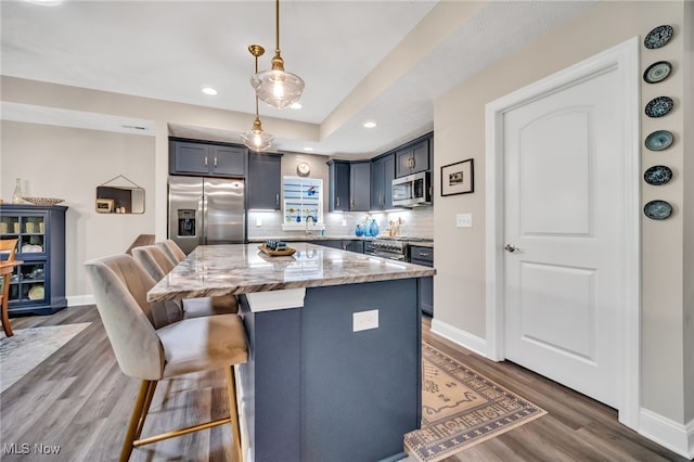 kitchen featuring stainless steel appliances, light stone countertops, a kitchen breakfast bar, baseboards, and recessed lighting
