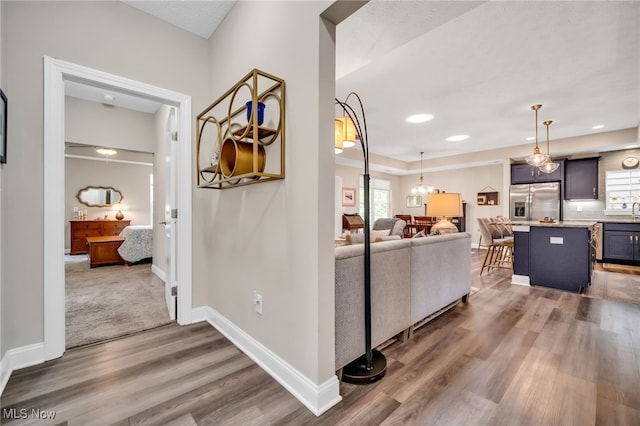 hallway featuring wood finished floors, baseboards, and recessed lighting
