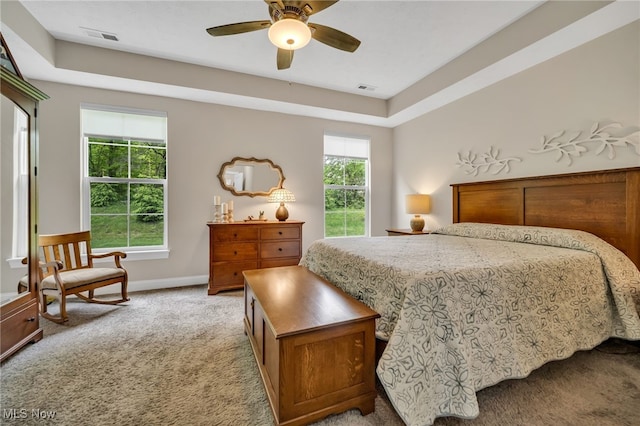 bedroom featuring light colored carpet, baseboards, and a ceiling fan