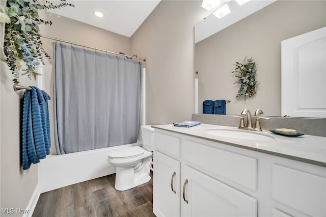 bathroom featuring wood finished floors, toilet, vanity, and shower / bath combo