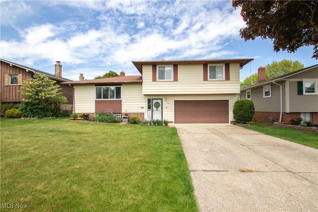 2720 Hetzel Dr, Parma, OH 44134 - split level home with an attached garage, concrete driveway, and a front yard