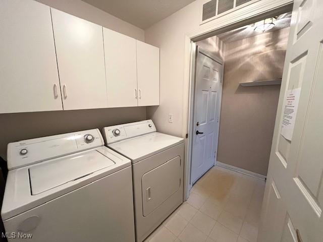23003 Chandlers Ln Unit 219, Olmsted Falls, OH 44138 - washroom featuring washer and clothes dryer, cabinet space, light tile patterned floors, and baseboards