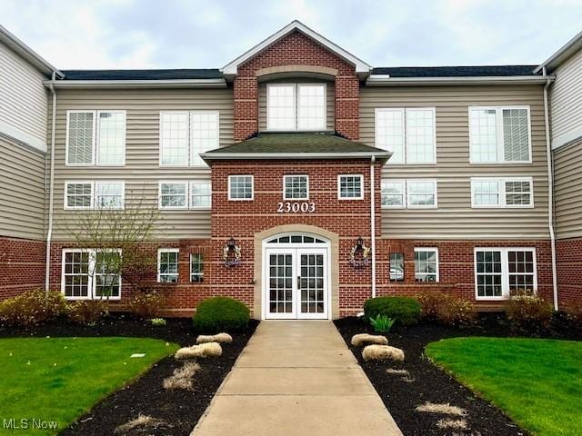 23003 Chandlers Ln Unit 219, Olmsted Falls, OH 44138 - doorway to property with french doors, brick siding, and a yard