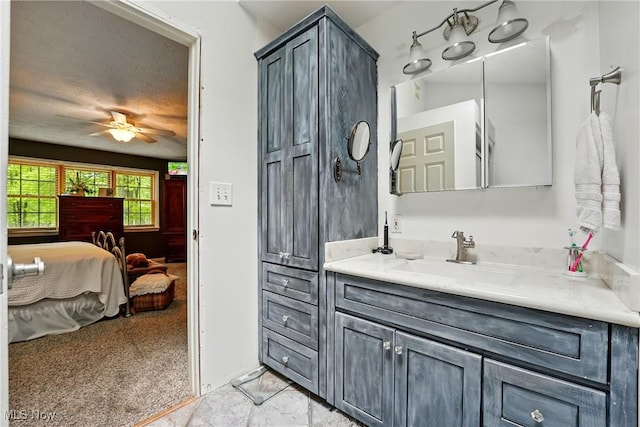 ensuite bathroom with a ceiling fan and vanity