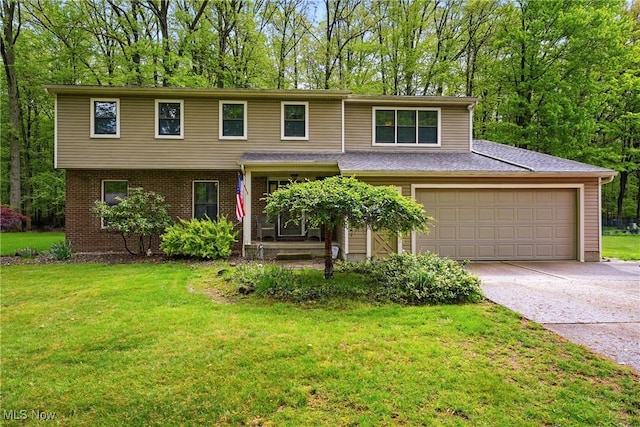 view of front of home with driveway, a front yard, a garage, and brick siding
