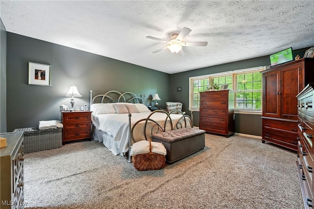 bedroom featuring light carpet, a textured ceiling, and a ceiling fan