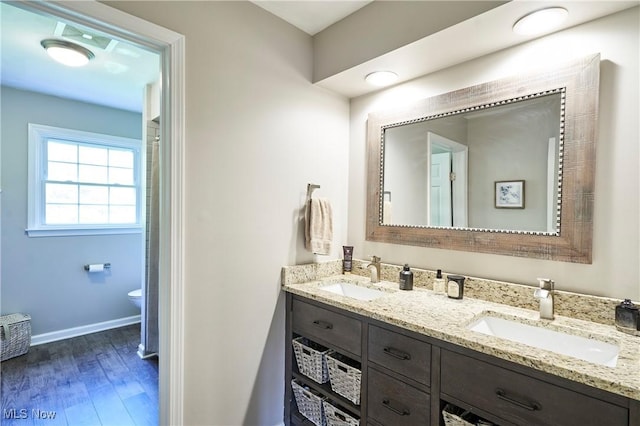 7304 Glastonbury Dr, Hudson, OH 44236 - bathroom with wood finished floors, double vanity, toilet, and baseboards