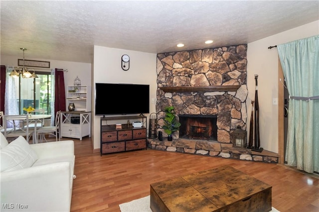 80 Landings Way, Avon Lake, OH 44012 - living room featuring a textured ceiling, wood finished floors, a chandelier, a fireplace, and recessed lighting