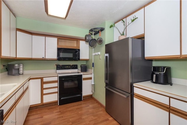 80 Landings Way, Avon Lake, OH 44012 - kitchen featuring black microwave, electric stove, freestanding refrigerator, light wood-type flooring, and light countertops
