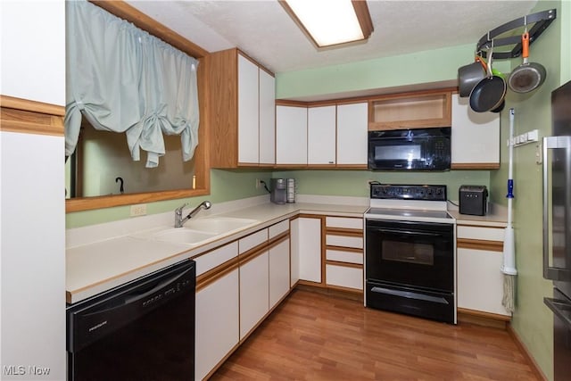 80 Landings Way, Avon Lake, OH 44012 - kitchen featuring black appliances, a sink, white cabinets, light countertops, and light wood-style flooring