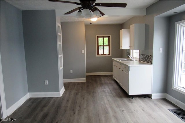923 W 58th St, Ashtabula, OH 44004 - kitchen featuring a ceiling fan, white cabinets, wood finished floors, and light countertops