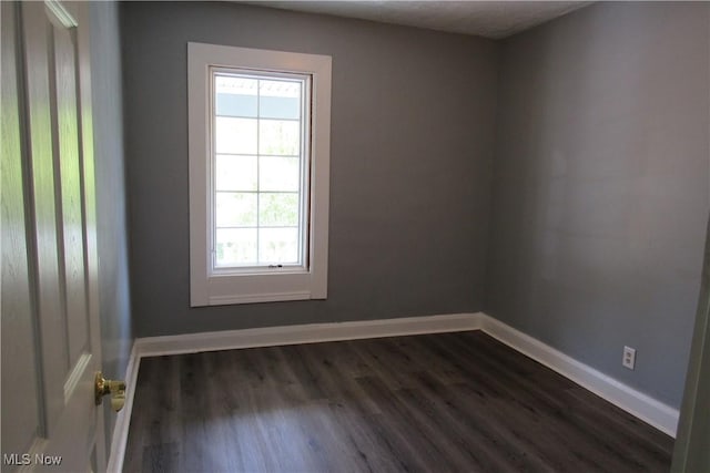 923 W 58th St, Ashtabula, OH 44004 - empty room with healthy amount of natural light, dark wood finished floors, and baseboards