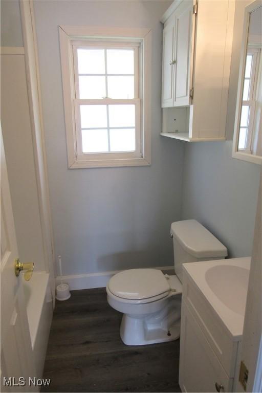 923 W 58th St, Ashtabula, OH 44004 - full bath with toilet, vanity, wood finished floors, baseboards, and a tub