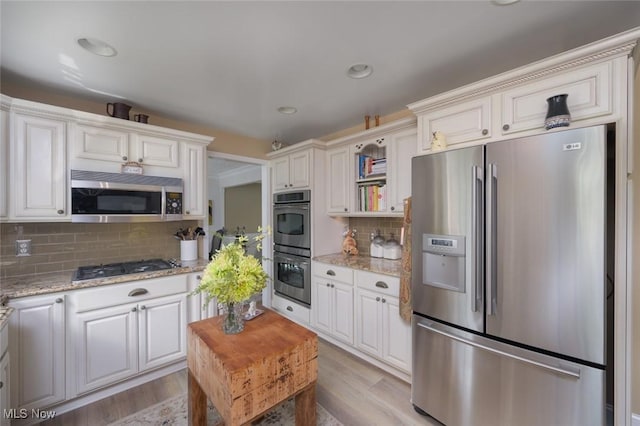 6352 Creekside Trl, Solon, OH 44139 - kitchen featuring appliances with stainless steel finishes, tasteful backsplash, light wood-style floors, light stone counters, and recessed lighting