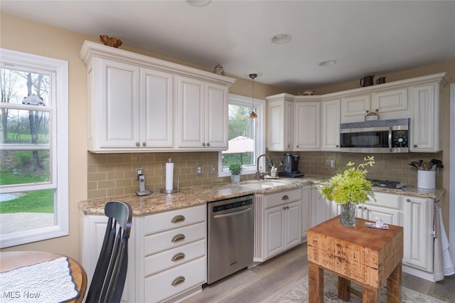 6352 Creekside Trl, Solon, OH 44139 - kitchen with stainless steel appliances, a sink, light wood-type flooring, and decorative backsplash