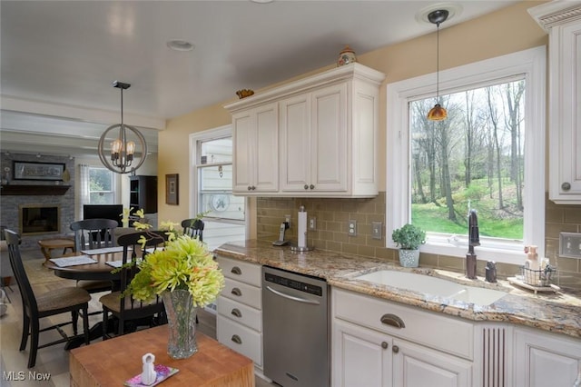 6352 Creekside Trl, Solon, OH 44139 - kitchen with stainless steel dishwasher, a sink, backsplash, a chandelier, and healthy amount of natural light