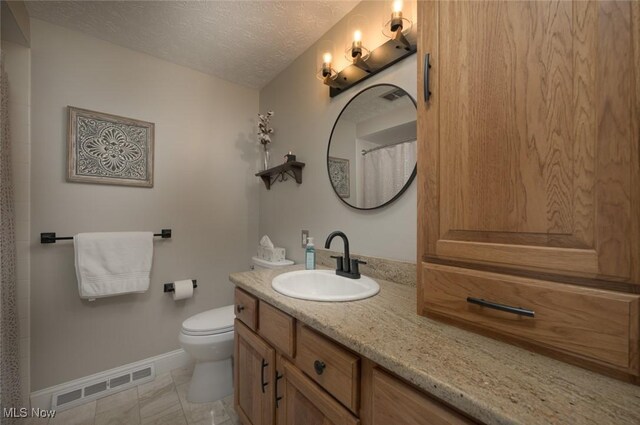 6352 Creekside Trl, Solon, OH 44139 - bathroom featuring baseboards, a textured ceiling, toilet, and vanity