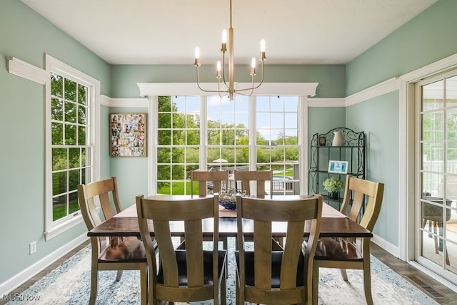 dining room featuring a chandelier, baseboards, and wood finished floors