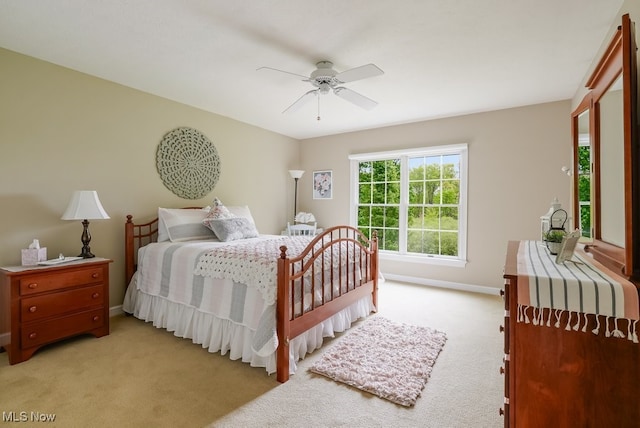 bedroom featuring light carpet, baseboards, and a ceiling fan