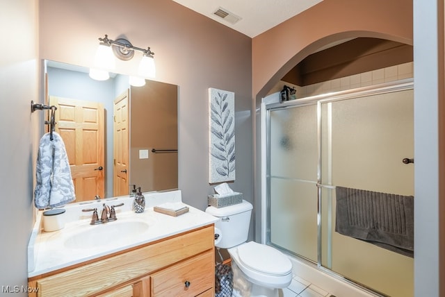 full bath featuring a shower stall, toilet, vanity, and tile patterned floors