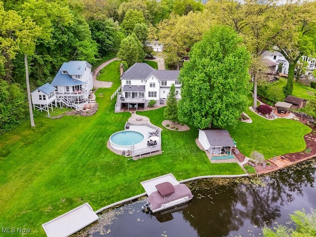 aerial view of property and surrounding area with a nearby body of water and a pool