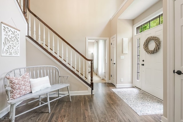 foyer featuring wood finished floors, stairway, and baseboards