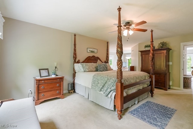 bedroom featuring light colored carpet, a ceiling fan, and baseboards