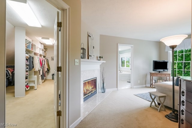 carpeted living area with a tile fireplace and baseboards