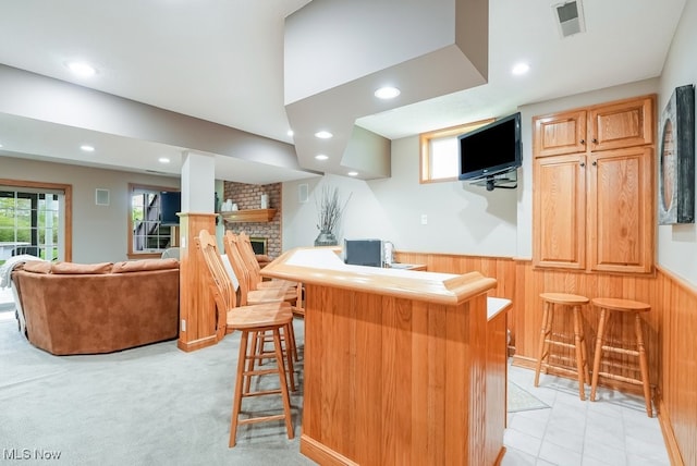 indoor wet bar with recessed lighting, wainscoting, wooden walls, and a fireplace