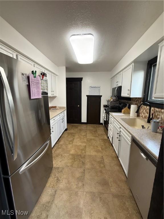 5460 Coronada Dr, Mentor-On-The-Lake, OH 44060 - kitchen with appliances with stainless steel finishes, a sink, light countertops, and white cabinets