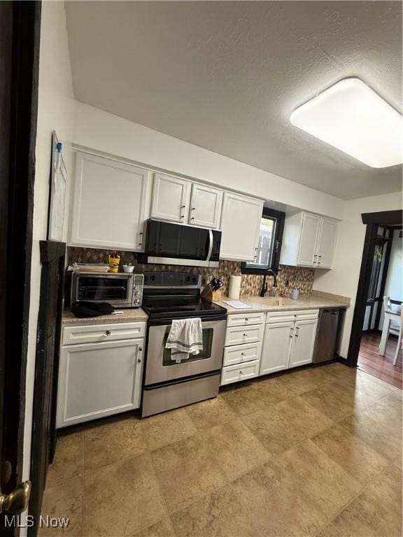 5460 Coronada Dr, Mentor-On-The-Lake, OH 44060 - kitchen with appliances with stainless steel finishes, decorative backsplash, white cabinetry, and light countertops