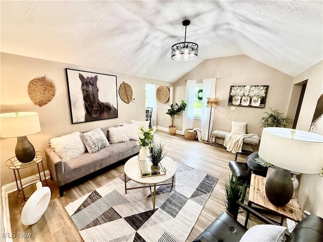 4812 Irma Ave, Youngstown, OH 44514 - living room featuring a textured ceiling, vaulted ceiling, baseboards, light wood-style floors, and a chandelier